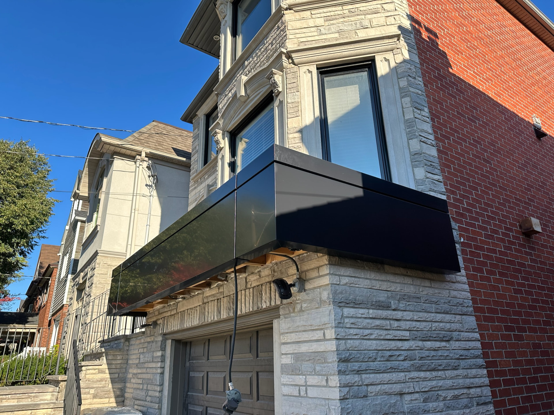 Black ACM panel canopy over a garage